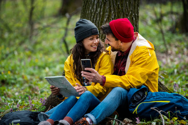 istock Hikers couple resting through forest, using smartphone and map to get good direction 1391100897