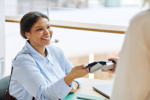 istock Smiling Woman using Credit Card in Cafe 1391101020