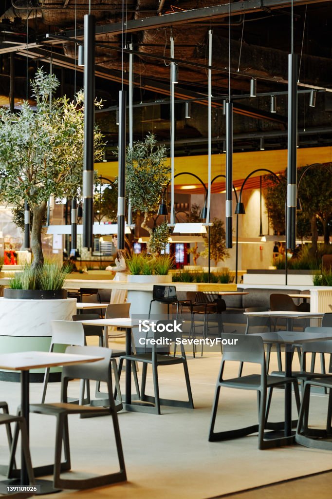 Green Food Court Interior Vertical background image of empty food court interior in shopping mall in loft style decorated by green live plants Shopping Mall Stock Photo