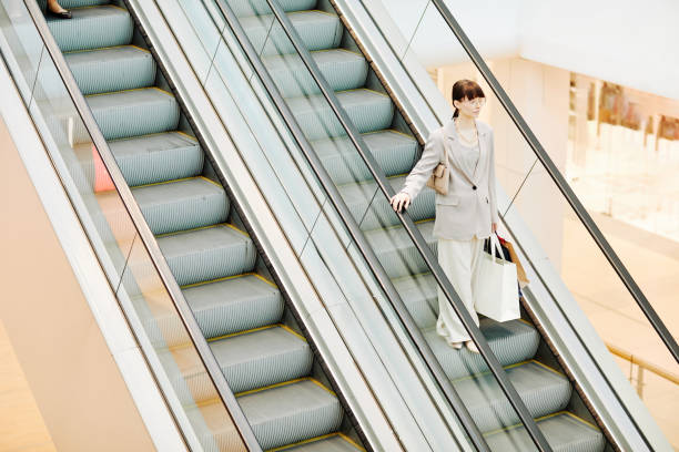 istock Woman on Escalator in Shopping Mall Minimal 1391101057