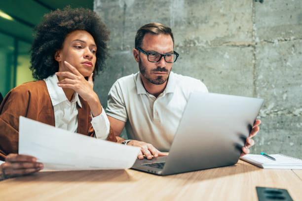 istock Two business people working together in office 1391103263