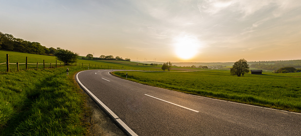 Panoramic view of a lonely country road and landscape in the Taunus on a sunny evening