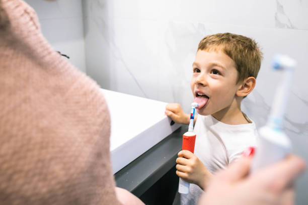 istock A cute boy cleaning his tongue with a toothbrush 1391103564
