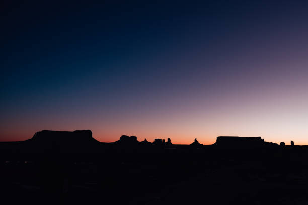 Silhouette of rock formations outlined by the glowing sky on a cold, winter morning