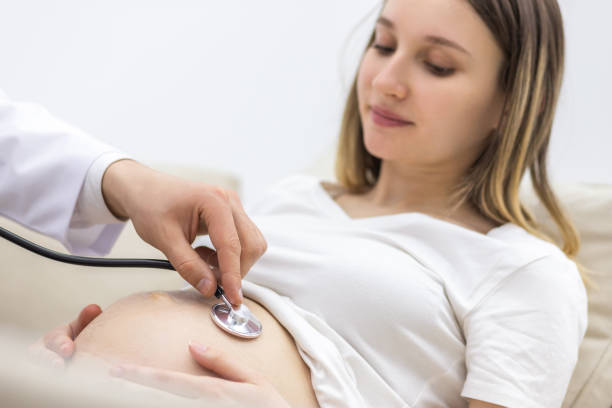 photo recadrée du médecin avec stéthoscope allant examiner la femme enceinte. - human pregnancy ultrasound medical exam doctor photos et images de collection