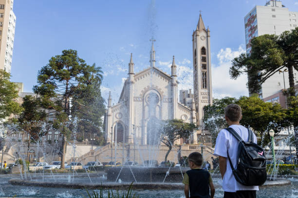 dois rapazes olhando para uma fonte na praça dante alighieri, em caxias do sul - alighieri - fotografias e filmes do acervo