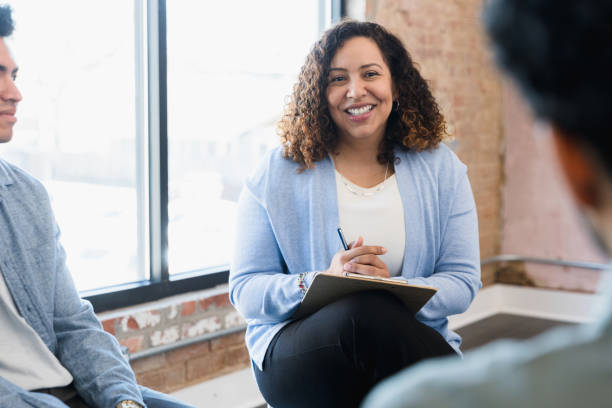 istock Female manager smiles at unrecognizable man seated across from her 1391105380
