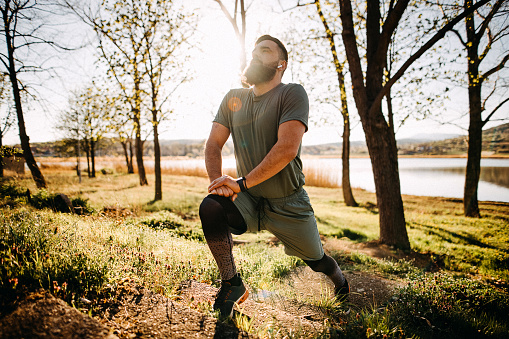 Shot of a sporty man starting his exercise routine with stretching exercises