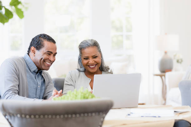 Grandparents proudly watching their grandchild's school performance Thankful for technology, the grandparents smile proudly while they watch their grandchild perform in their school play. financial advisor virtual stock pictures, royalty-free photos & images