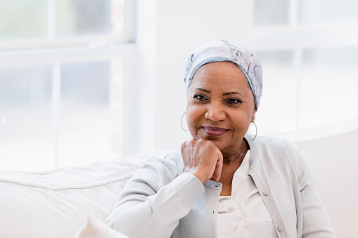 The beautiful senior woman sits in silence while she has a contemplation look on her face.