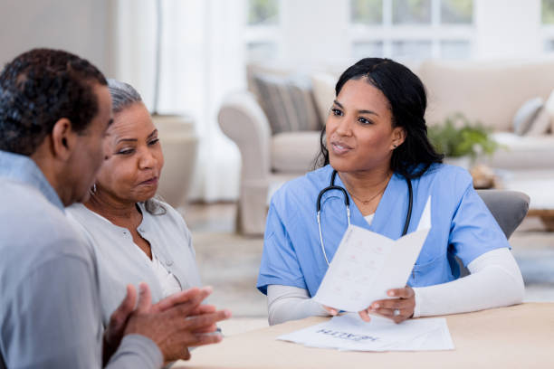 nurse helps point out information on the pamphlet - common serious couple men imagens e fotografias de stock