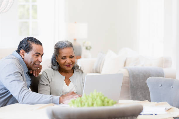 istock Senior wife smiles as husband helps her navigate tax forms 1391107085