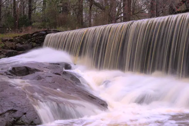 Long exposure shot of the Historic Yates Mill Dam overflowing after a severe downpour.