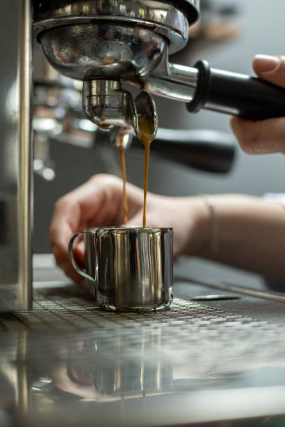 istock Female barista making coffee in professional coffee machine 1391109762
