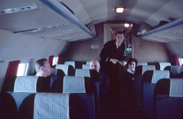 Rhein-Main Airport, Germany, 1958. Stewart and passengers in a flight cabin.