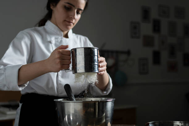 istock Woman bakery chef sifting flour from sieve 1391110030