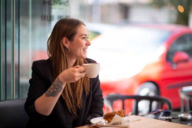 Young woman drinking coffee in a cafe stock photo