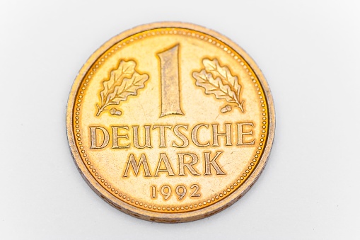 Gilded German one mark coin from 1992.\nGold-plated German Deutsche Mark (D Mark) coin, official currency from 1948 until the completion of the European Economic and Monetary Union in 2002. The euro has been the sole legal tender in the Federal Republic of Germany and the European Union since 2002. \nThis image is part of a money concepts series.