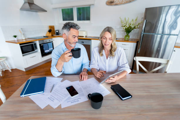 istock Mature couple doing paperwork and paying bills at home. 1391116259
