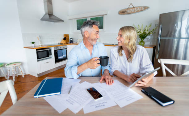 istock Mature couple doing paperwork and paying bills at home 1391116260