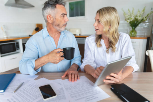 istock Mature couple doing paperwork and paying bills at home. 1391116265