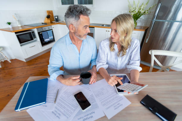 istock Mature couple doing paperwork and paying bills at home. 1391116775