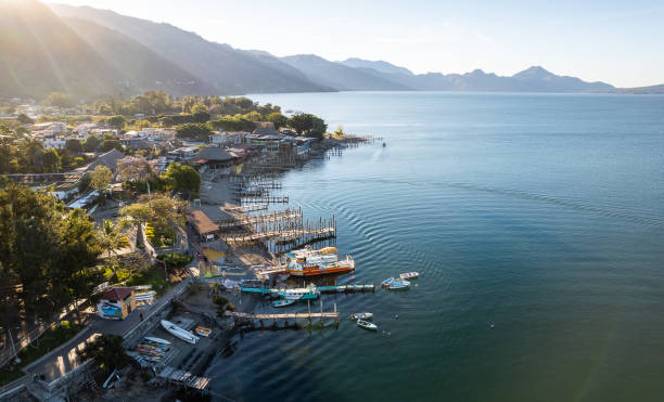 Young Caucasian woman  sitting on pier on Atitlan Lake in Guatemala at sunset
