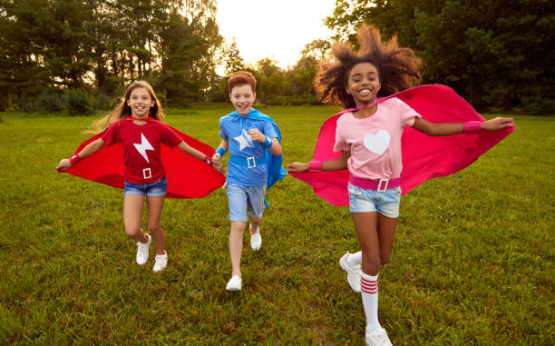 istock Cheerful little superheros running in park 1391129757