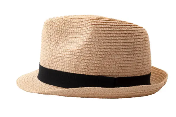 Summer and beach fashion, personal accessories and holiday head wear concept theme with a straw hat or fedora with a black strap or ribbon isolated on white background with a clip path cutout