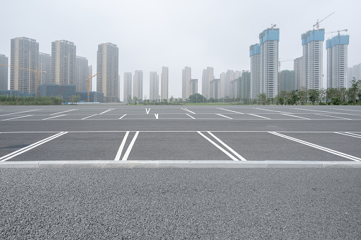 Empty parking spaces and distant urban buildings in haze weather