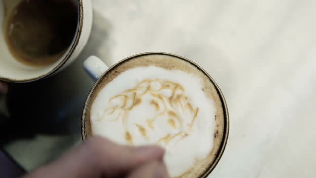 Professional Barista making pouring stream milk latte art pattern in cup. stock video