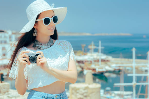 Cheerful tourist taking photos with vintage analogue camera
