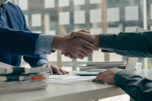 business people meeting in modern room Hand in hand for business success Employees shake hands with each other, brainstorming for innovative businesses. Successful Investment Agreement Concept stock photo