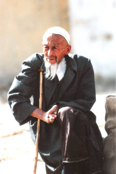 In Hotan city, an old Uighur man rests while sitting on the roadside.He look serene, with distinctive features, and distinctive costumes, and they are typical indigenous Uighurs and an ethnic minority with a large population in China.Film photo in 1996's Xinjiang Hetan