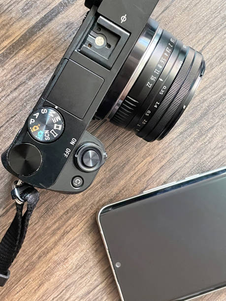 istock Photo camera and smartphone on a wooden table 1391145322