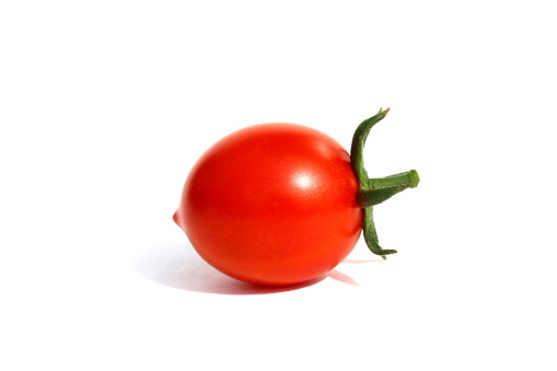 Red ripe small tomato lies on a white background.