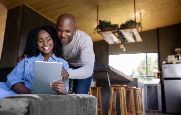 istock Happy couple at home looking at social media on a tablet computer 1391148888