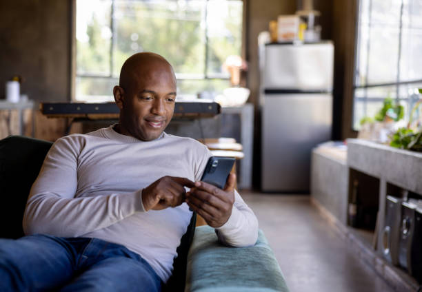istock Man at home using an app on his cell phone 1391148934