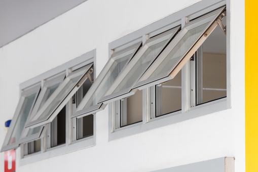 silver aluminium frame windows background, grey awning windows. modern home aluminium push windows. toilet ventilation.