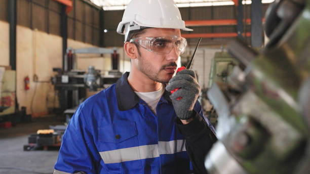 istock engineer using walkie talkie for communicate with his team in industry factory. 1391150407