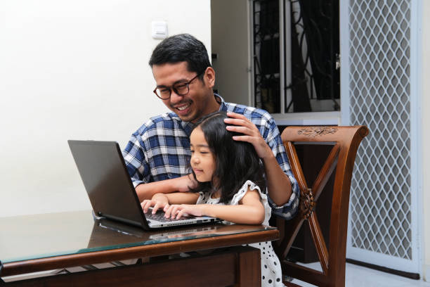 istock Asian father accompany his daughter when learning something using a laptop 1391157694