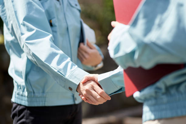 Construction worker shaking hands in front of the building Construction worker shaking hands in front of the building coalition building stock pictures, royalty-free photos & images