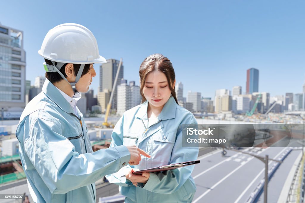 Asian workers having a meeting at the construction site Construction Site Stock Photo