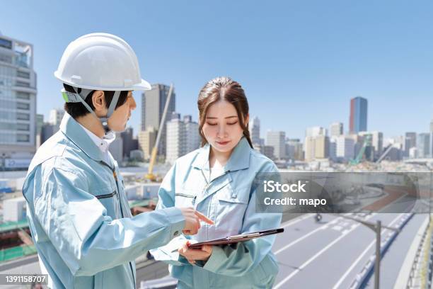 Asian Workers Having A Meeting At The Construction Site Stock Photo - Download Image Now