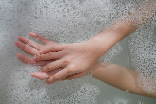 Close up woman hand with fizzy bubble in bathtub