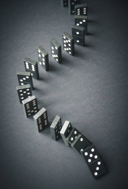 istock Black dominoes chain on dark table background 1391164646