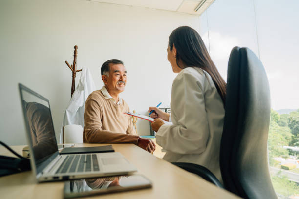 Senior male patient having appointment for medical checkup with doctor stock photo