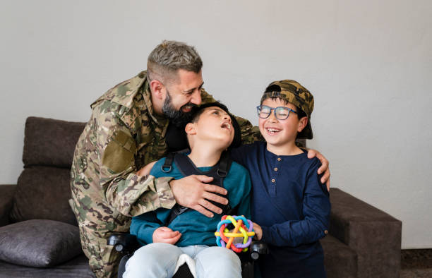 familia con padre militar y niño en silla de ruedas abrazándose - personal militar español fotografías e imágenes de stock