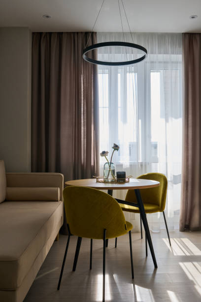 istock Two mustard yellow chairs standing by round table in spacious kitchen 1391168973