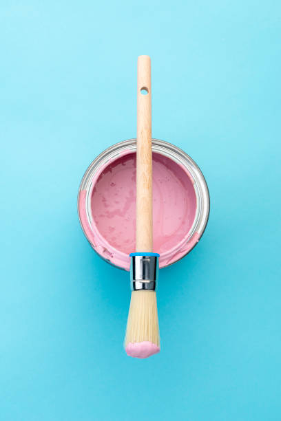 istock Brush on open can of pink paint on blue pastel background 1391170532